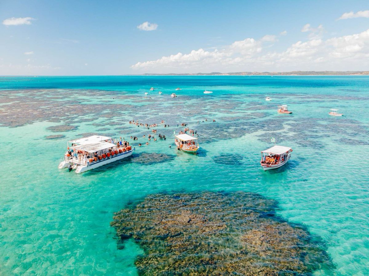 Barcos junto a las piscinas de coral, con la bajamar